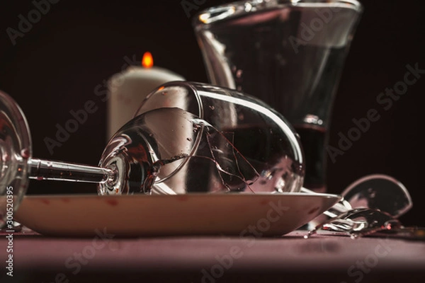 Fototapeta Broken goblets and broken glass on a table filled with red wine.