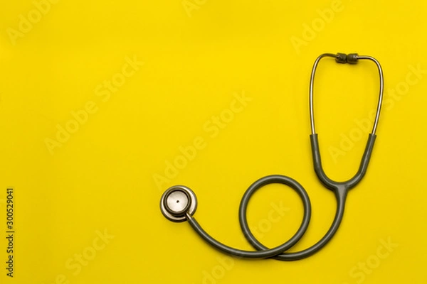 Obraz Stethoscope on a yellow background with space for text.