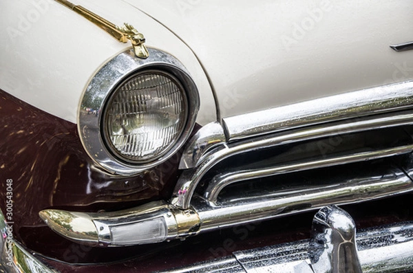 Obraz The front part of the retro car, a fragment of the brilliant design of the old means of transport, close-up, copy space, toned.