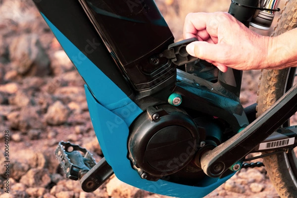 Fototapeta Close up of the motor and battery of a black e bike. Outdoor activity with bicycle for healty lifestyle