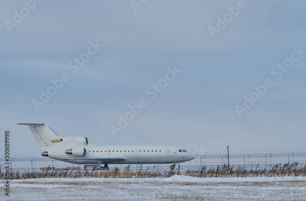 Fototapeta Plane at the airport on the runway in winter. Aircraft winter runway