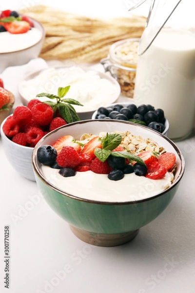 Fototapeta Tasty homemade granola served on table. Healthy breakfast with a bowl of oatmeal with banana, blueberries, strawberries and healthy food for Breakfast