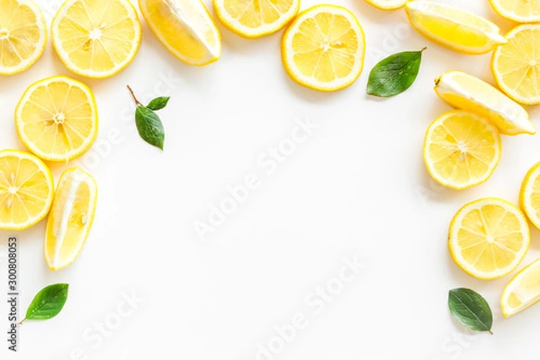 Fototapeta Fruit frame. Lemons and leaves on white background top view close up copy space