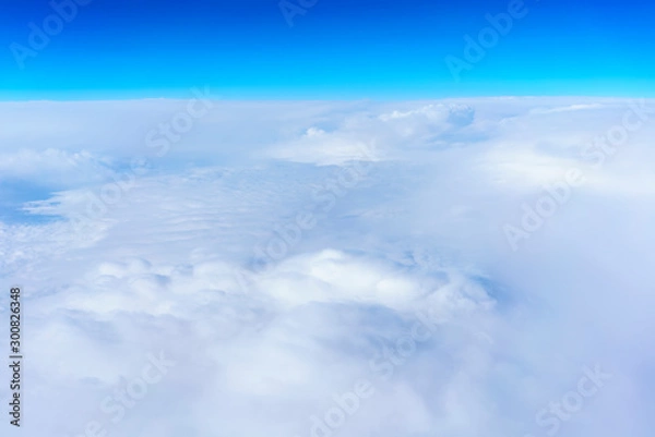 Obraz Aerial view from Airplane's window viewing white clouds and blue sky