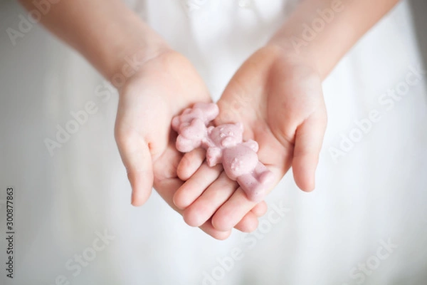 Fototapeta delicious pink handmade chocolate in the hands of a girl. celebration and tea party. The view from the top, Flatley. chocolate with nuts and marzipans