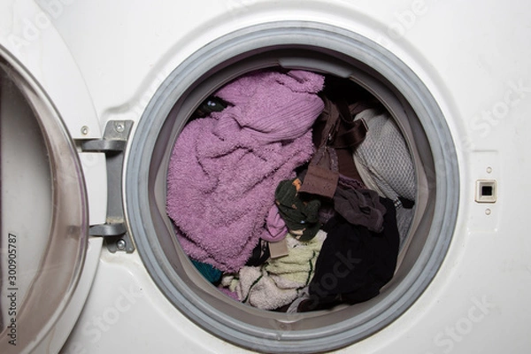 Obraz Washing machine broken. Things that were washed in the washing machine are spoiled.
