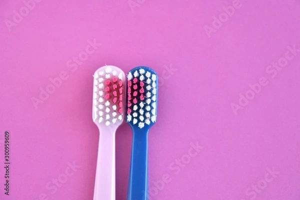 Fototapeta Toothbrush for personal healthcare dental care on purple background.Two bright toothbrushes with red heart. Toothbrush for personal healthcare. St. Valentine's Day concept. Lovers toothbrushes