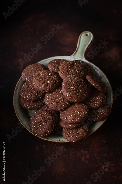 Fototapeta Chocolate cracked cookies with chocolate and sesame seeds. On a ceramic decorative dish
