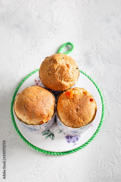 Fototapeta Homemade Easter cakes in paper wrapper. Light background