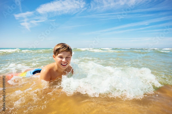 Obraz Fun in the wave boy lay on sea beach water edge