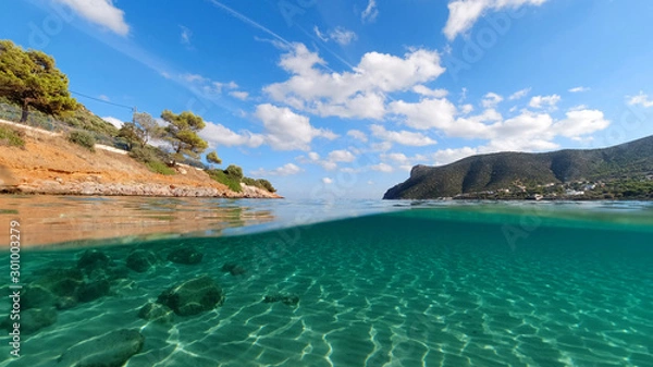Fototapeta Above and below underwater photo of tropical exotic turquoise sandy beach in Caribbean secluded destination with deep blue sky and clouds