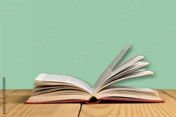Obraz Open book, hardback books on wooden table.