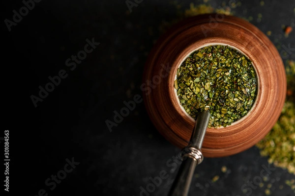 Fototapeta Beautiful composition of yerba mate on a black background - Juicy and green leaves without sticks
