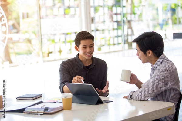 Fototapeta Asia Gay Couples Work Freelance Together in an Office Using Tablet and Computers