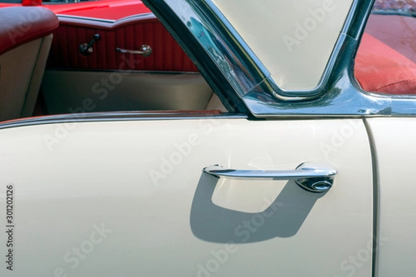 Fototapeta close up of a white classic car with red interior and loads of chrome.
