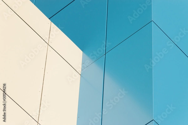 Fototapeta Geometric color elements of the building facade with planes, lines, corners with highlights and reflections for the abstract background and texture of blue, turquoise, white colors. Place for text