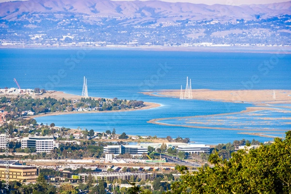 Obraz Aerial view of wetlands in the San Francisco Bay Area; Office buildings, residential areas and electricity towers visible on the shoreline; San Carlos, California