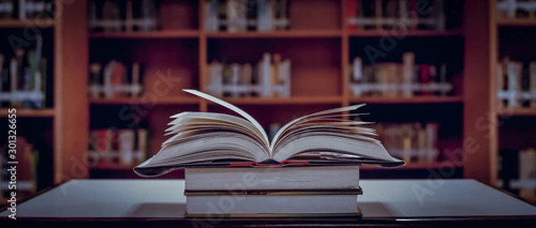 Obraz Stack of books in the library and blur bookshelf background