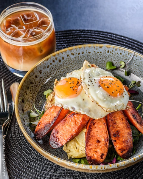 Fototapeta German Potato Salad with fried eggs and Chorizo in a blue bowl.