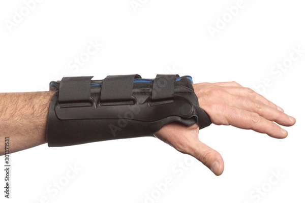 Fototapeta human hand with a wrist brace, orthopedic equipment isolated on white background with clipping path and copy space for your text