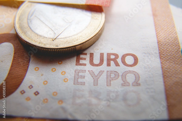 Obraz Macro photo of a coin in 1 Euro on a blurred background banknote in 50 euro. Money background. Extremely small depth of field.
