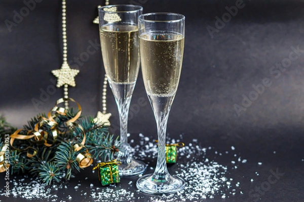 Fototapeta Christmas mood. Glasses with champagne. New Year. Christmas-tree decorations, coniferous branches. Copy space. 