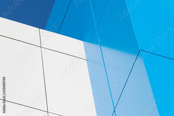 Obraz Geometric colored building facade elements with planes, lines and corners with light flare and reflections for an abstract background and texture of white, blue, gray colors. Place for text