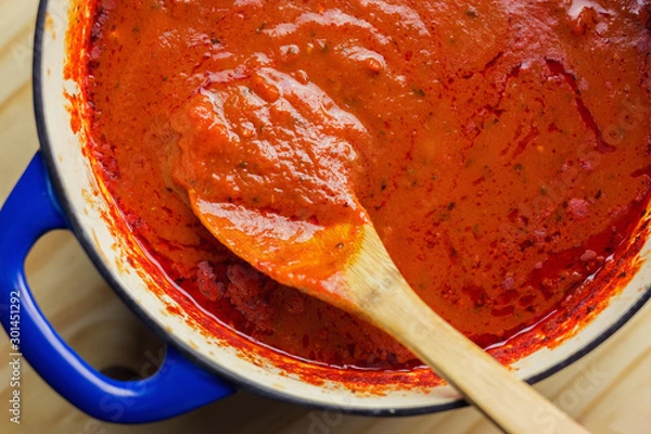 Obraz Authentic marinara sauce shown with wooden spoon in a cast iron dutch oven. 