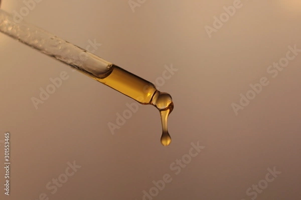 Fototapeta Closeup of a piepette with organic rosehip oil on a white background. 