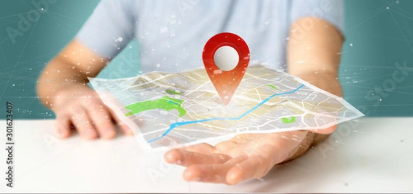 Fototapeta Man holding a 3d rendering pin holder on a map