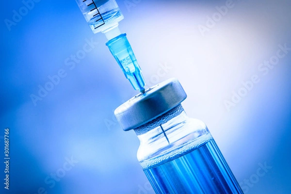 Fototapeta Close up of flu and measles vaccine vials with syringe injection, medicine and drug concept