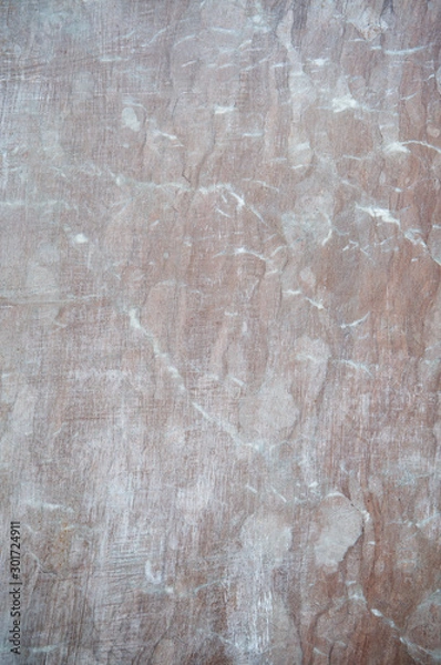 Fototapeta Marbled brown red stone background featuring light marks from cuts and scratches