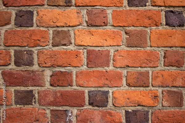 Fototapeta Background, bright red brick wall of an old building. Brick textured masonry