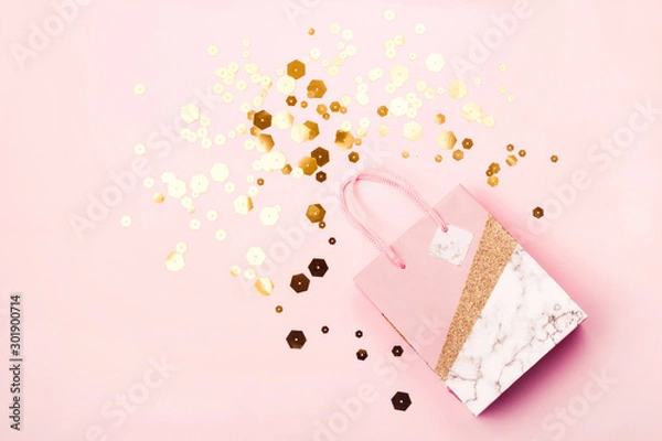 Fototapeta Geometric paper shopping bag and trendy hexagonal sparkles on pink background. Holiday sale concept