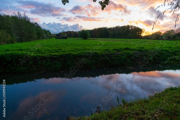 Obraz sunset over field and canal