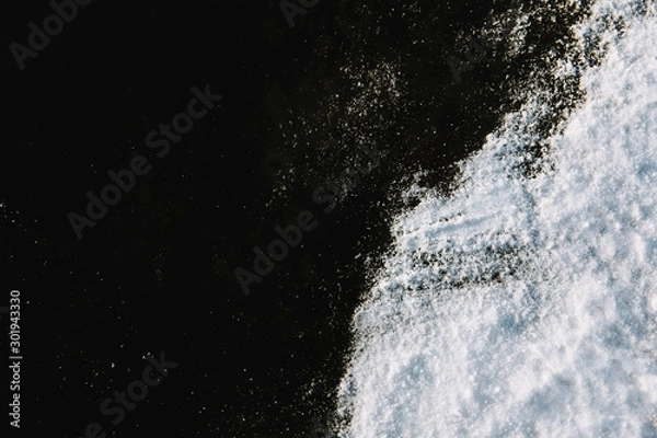 Obraz White snow on black ice background. Top down view.