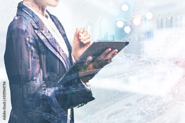 Fototapeta Concept double exposure Female business women who use tablet computer to work mix with background of the city is blurred, City life and internet usage on a daily basis