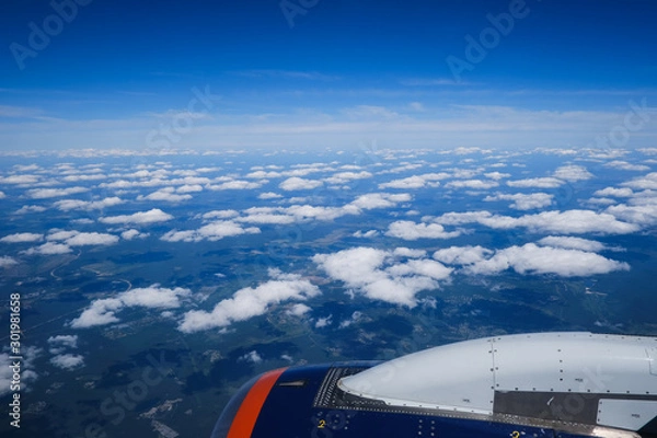 Fototapeta Clouds and sky as seen through window of an aircraft