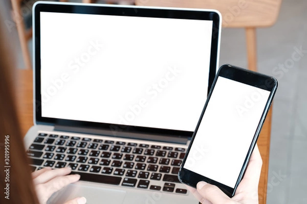 Fototapeta mockup image computer,cell phone blank screen for hand typing text,using laptop contact business searching information in workplace on desk at office.design creative work space on wooden desk