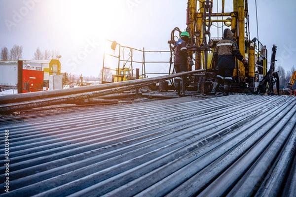 Fototapeta Oil Drill pipe. Rusty drill pipes were drilled in the well section. Downhole drilling rig. Laying the pipe on the deck. View of the shell of drill pipes laid in courtyard of the oil and gas warehouse