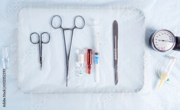 Fototapeta Surgical clamps, scalpel and syringe on the table