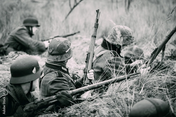Fototapeta Wehrmacht soldiers in the trenches with rifles on the black white image