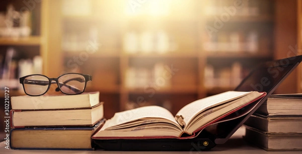 Fototapeta Stack of books in the library and blur bookshelf background
