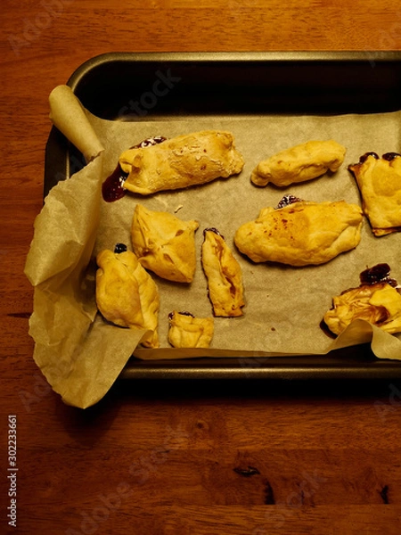 Fototapeta Homemade bakery dessert, cookies made by children. Top view of handmade ugly pastries on the pan