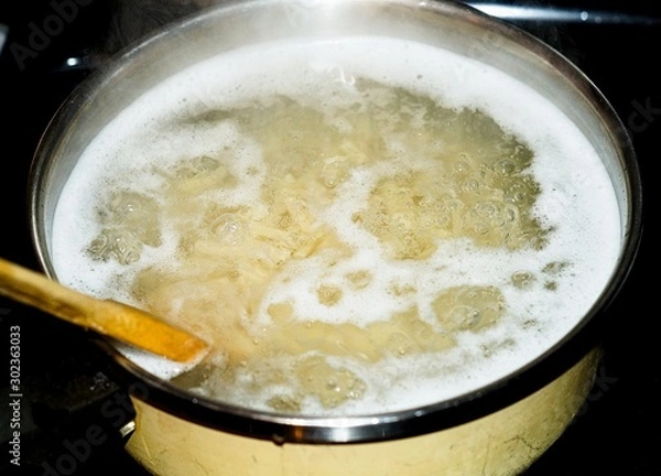 Fototapeta Macaroni boiling in a pot of water 