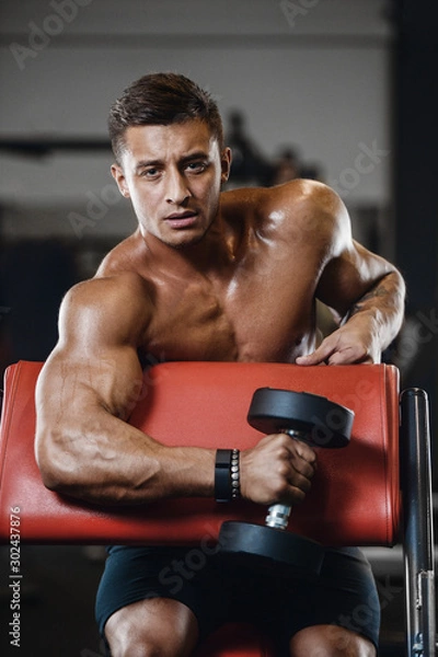 Fototapeta Handsome strong athletic men pumping up biceps muscles workout fitness and bodybuilding concept background - muscular bodybuilder fitness men doing arms exercises in gym naked torso.