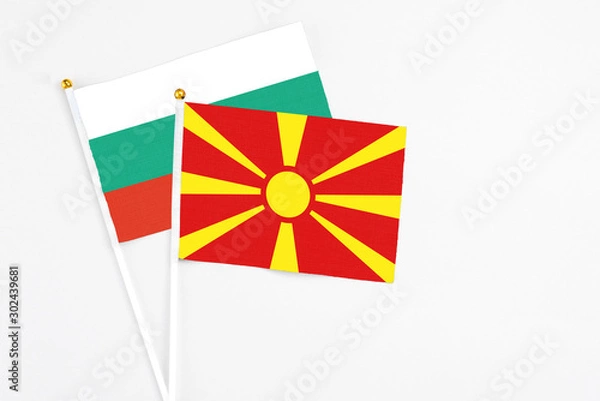 Fototapeta Macedonia and Bulgaria stick flags on white background. High quality fabric, miniature national flag. Peaceful global concept.White floor for copy space.
