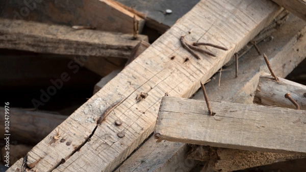 Obraz Dangerous sharp tip of rusty nail on hard wood in construction area, risk to get injury accident for worker, risk management or safety concept
