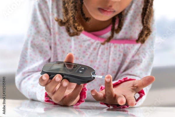 Fototapeta Concept children diabetes children with glucometer learning to check blood sugar level at home. Learn to use a glucometer