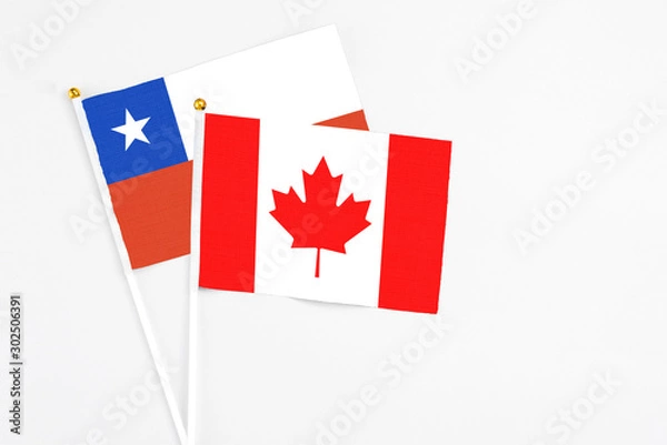 Fototapeta Canada and Chile stick flags on white background. High quality fabric, miniature national flag. Peaceful global concept.White floor for copy space.